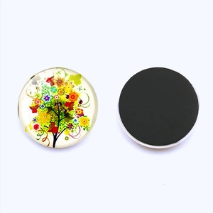 Gros plan sur l'aimant de frigo arbre de vie en verre avec motif floral coloré et aimant