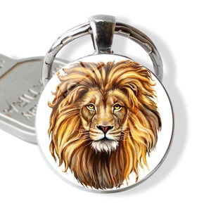 Close-up of a silver lion head glass dome keychain with vibrant artistic illustration
