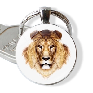 Detailed macro view of a silver metal lion head keychain with clear glass dome design