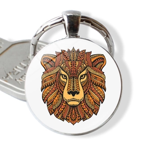Macro detail of lion head glass pendant keychain with orange tribal mandala art design