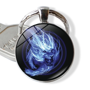Macro view of blue lion head art glass cabochon pendant with silver metal keyring