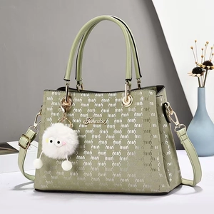 Détail du cabas vert pistache avec logos embossés et charmant pendentif en peluche