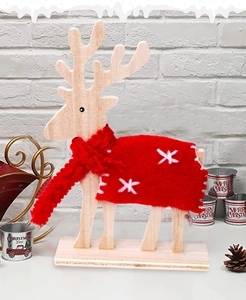 Close-up of wooden reindeer with red felt shawl and snowflake embroidery detail