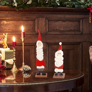 Detail of wooden Santa figurines with woven cotton beards on a festive mantel