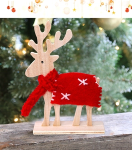 Detail of wooden Christmas reindeer decor with red wool scarf and snowflake felt coat
