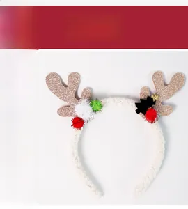Detail of Christmas headband with gold sequined antlers, colorful pom poms and plush texture