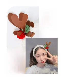 Detail of plush Christmas reindeer antlers headband with festive red and green pompoms