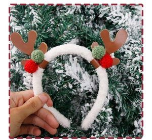 Detailed close-up of Christmas reindeer antler headband with plush balls and faux shearling
