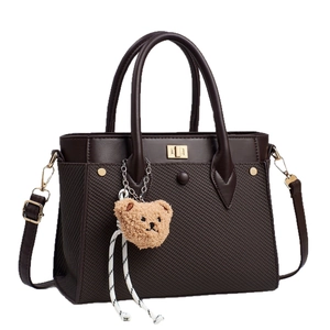 Dark brown woven handbag with leather trim and cute plush bear charm for stylish women