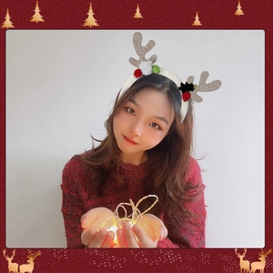 Christmas reindeer antler headband with silver sequins and colorful pom poms on a model