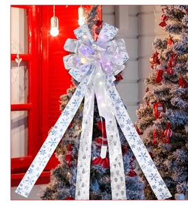 Close-up of LED glowing Christmas bow with silver tree prints and a white battery box