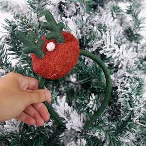 Detail of plush green reindeer antlers on a Christmas headband with a white pom-pom
