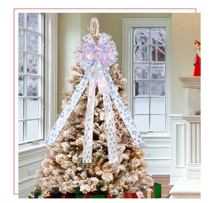 Close-up of LED glowing Christmas bow with silver snowflake print on white Xmas tree