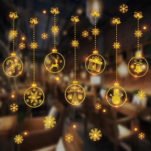 Close-up of golden glitter Christmas window stickers with snowflake and reindeer motifs