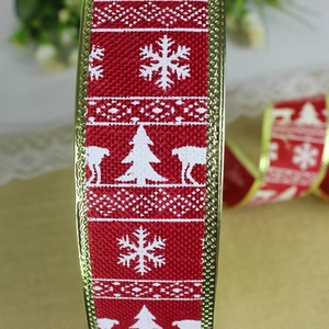 Macro shot of red faux linen Christmas ribbon with gold edges and reindeer prints