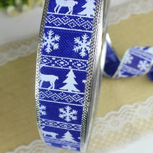 Close-up of blue linen Christmas ribbon with white reindeer and snowflake prints