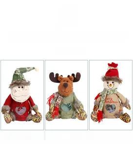 Detalle de tres bolsas de regalo de Navidad en yute con Papá Noel, Reno y Muñeco de nieve