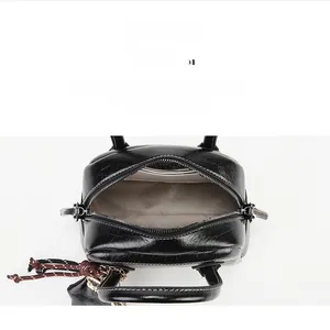 Détail montrant les compartiments intérieurs et la poche zippée de ce sac à main noir