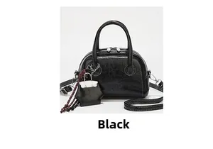 Détail du sac Boston rétro noir avec texture cuir huilé vintage et mini bijou de sac