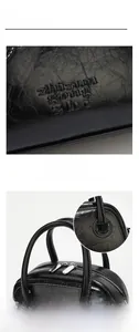 Détail d'un sac à main en cuir noir gaufré avec double fermeture et poignées solides