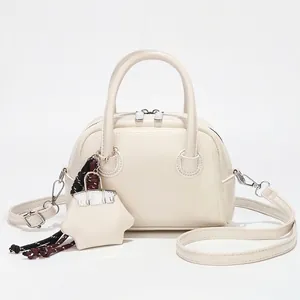 Sac à main bowling élégant en cuir blanc crème avec doubles poignées et breloque gland