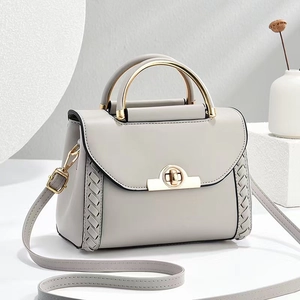 Sac bandoulière en cuir gris clair avec côtés tressés et poignée en métal doré
