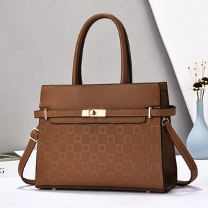 Detail of brown leather handbag with checkered pattern texture and gold twist-lock