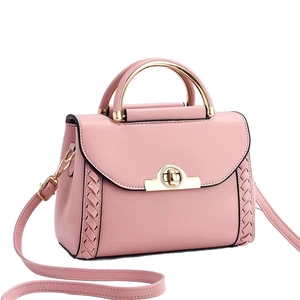 Sac selle macaron en cuir rose avec poignée en métal doré et bandoulière sur fond blanc