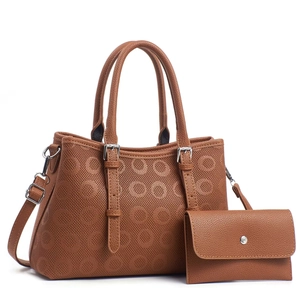 Detail view of dark brown embossed leather handbag set with matching long wallet on white