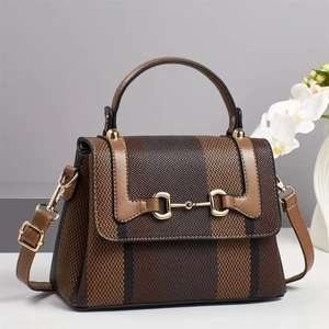 Close-up of contrast stripe canvas bag with leather trim and gold horsebit detail