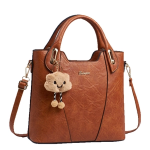 Brown vintage textured bucket bag with macaron cloud charm and adjustable strap