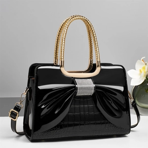 Sac à main en cuir verni noir avec nœud en strass et poignées dorées