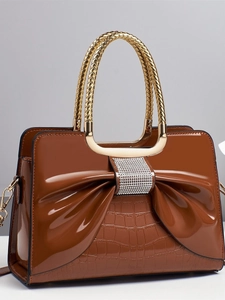 Sac à main en cuir verni marron avec nœud et poignée tissée en métal doré