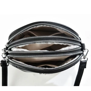 Close-up of black crossbody bag showing three zipper compartments and inner fabric lining