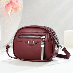 Burgundy lychee pattern faux leather crossbody bag with triple zipper and silver accents