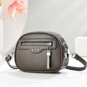Brown lychee-texture leather crossbody bag with multiple silver zippers and a long tassel