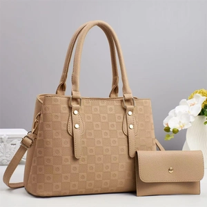 Détail du cuir gaufré à damier sur le sac à main marron avec des finitions en métal doré