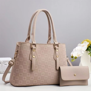Détail d'un sac à main beige texture litchi et son portefeuille assorti avec pièces dorées