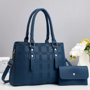 Dettaglio della borsa blu navy in pelle testurizzata con hardware dorato e motivo a quadri