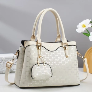 Close-up of beige tote bag with letter embossing, matching mini coin purse and golden hardware