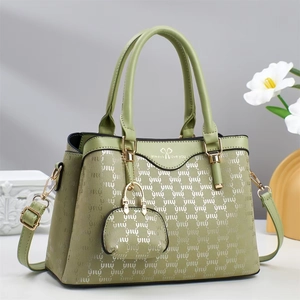 Detail of light green tote bag with UIU pattern, hanging purse and gold metal hardware