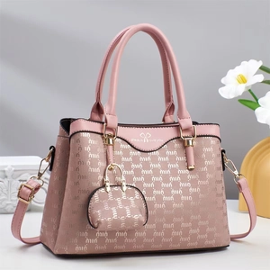 Pink fashion handbag with embossed lettering texture and adjustable shoulder strap detail