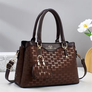 Detail of dark brown tote bag with letter pattern, bow logo, and detachable coin purse