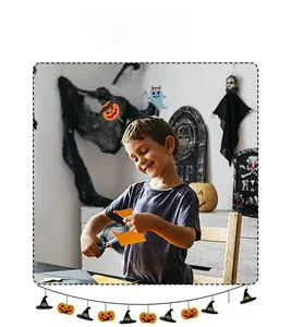 Young boy wearing a Halloween pumpkin headband while crafting in a spooky festive room