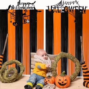 Halloween party backdrop set with orange and black fringe curtains and festive felt banners