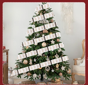 Close-up of festive white ribbon with golden HOHO print decorating a Christmas tree