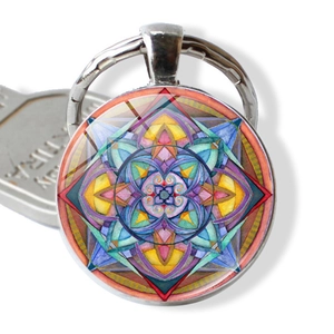 Macro detail of mandala glass dome keychain with geometric art in silver metal frame