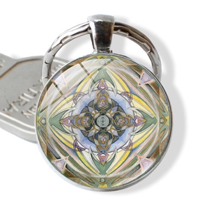 Macro view of round glass mandala keychain with colorful geometric pattern and silver frame