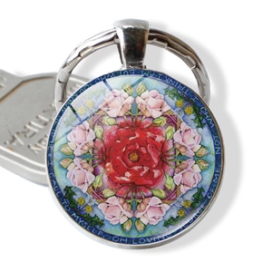 Detailed macro shot of a round mandala glass pendant keychain with red rose design