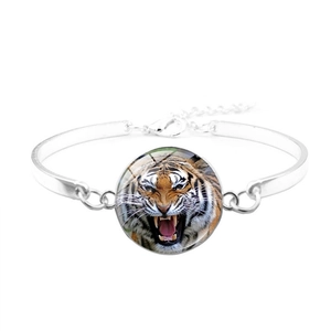 Gros plan détaillé du médaillon tigre en verre sur un bracelet jonc argenté ajustable